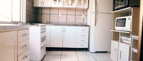 Apartamento, 3 quartos | Cozinha privada | Geladeira, micro-ondas, fogão, cooktop