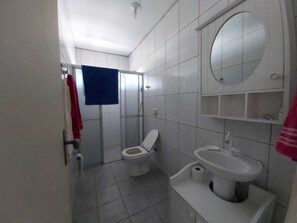 Ein Badezimmer mit Toilette, Waschbecken und Spiegel.