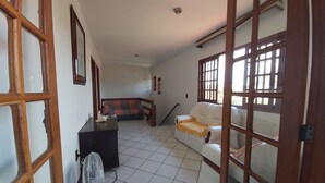 Un salon avec un canapé, une petite table et un ventilateur.