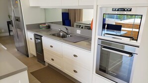 Een moderne keuken met roestvrijstalen apparatuur, witte keukenkastjes en een ingebouwde oven.