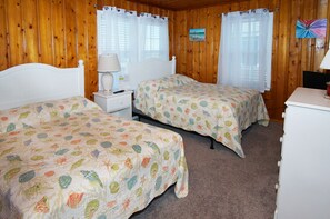 A room with two beds, wooden walls, and a small desk with a lamp. - Cozy & pet-friendly oceanfront apartment steps from the sand-beautiful oceanfront balcony (North Myrtle Beach)