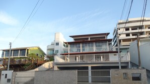 Een meerlaags woongebouw met een balkon, een hekpoort en een trap die naar de bovenverdiepingen leidt.