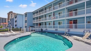 Un hôtel doté d’une piscine, de plusieurs balcons et d’un panneau indiquant qu’il n’y a pas de sauveteur en service.
