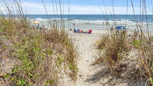 A beach path leading to the ocean with beachgoers and beach chairs. - Soothing stay at this oceanfront condo w/pool, sundeck, priv balc, grill in popular North Myrtle (North Myrtle Beach)