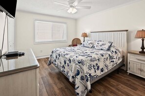 A bedroom with a bed, bedside tables, a lamp, a ceiling fan, and a window with blinds. - Soothing stay at this oceanfront condo w/pool, sundeck, priv balc, grill in popular North Myrtle (North Myrtle Beach)