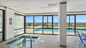An indoor swimming pool with clear views of the beach, a no-jumping sign, and a shallow water warning sign. - Panoramic ocean views, pool, hot tub, close to shops, restaurants and Cherry Grove Beach (North Myrtle Beach)