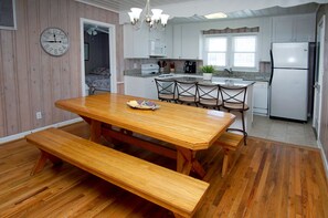 Enjoy meals in the kitchen with a dining table and benches, a refrigerator, and oven.