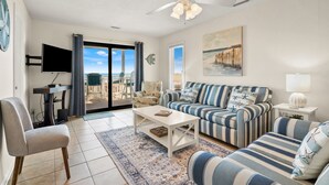 A living room with a sofa, armchairs, a coffee table, and a TV.