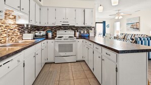 A modern kitchen with white cabinets, a built-in oven, and a granite countertop.