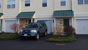 A multi-story residential building with a garage on the ground floor. - Rehoboth Beach Condo (Rehoboth Beach)