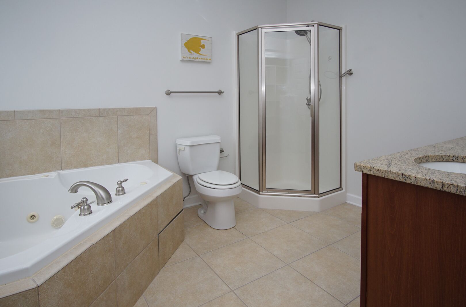 A bathroom with a bathtub, toilet, and glass-enclosed shower.