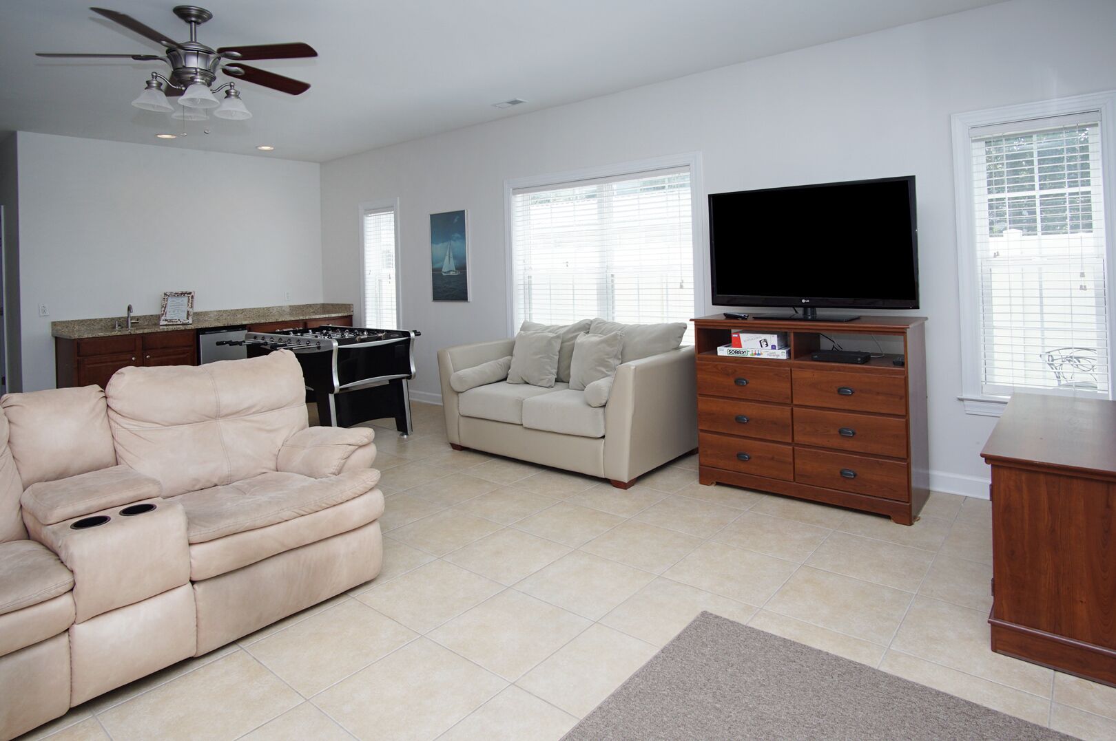 A living room with a beige sofa, a television, and a wooden cabinet.