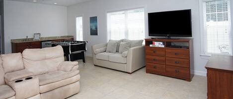 A living room with a beige sofa, a television, and a wooden cabinet.