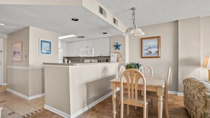 A spacious living area with a kitchen, dining table, and a cozy seating area. - Oceanfront panoramic views, indoor pool, Jacuzzi, balcony--in favorite North Myrtle Beach (North Myrtle Beach)