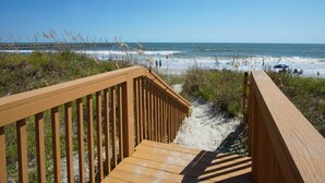 A wooden boardwalk leading to a beach with a pier in the background. - Oceanfront panoramic views, indoor pool, Jacuzzi, balcony--in favorite North Myrtle Beach (North Myrtle Beach)