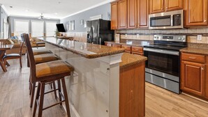 Una cocina moderna con armarios de madera, electrodomésticos de acero inoxidable y encimera de granito.