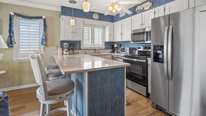 A modern kitchen with a central island, stainless steel appliances, and a ceiling fan. - Charming oceanfront condos w/pool, price-friendly in perfect area - North Myrtle Beach rental (North Myrtle Beach)