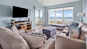 A spacious living room with a large TV, comfortable seating, and a view of the ocean. - Beautiful, dog-friendly w/amazing ocean views (North Myrtle Beach)