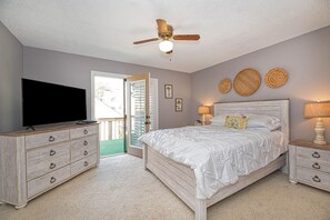 Cozy retreat with a central bed, dresser, and television, offering a peaceful atmosphere.