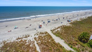 A beach with a lifeguard tower, sandy dunes, and a clear view of the ocean. - Beautiful ocean & beach views, oceanfront condo w/pool, sundeck, family friendly-North Myrtle Beach (North Myrtle Beach)