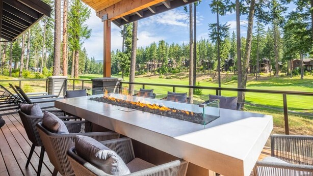 An outdoor deck with a large rectangular table, wicker chairs, and a built-in fire feature. - Golf View, Hot Tub, Suncadia Pool Access (Cle Elum)
