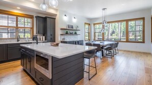 A spacious kitchen with a large island, dark cabinetry, and pendant lighting. - Golf View, Hot Tub, Suncadia Pool Access (Cle Elum)