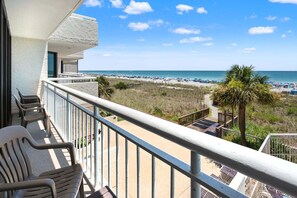 A balcony with chairs overlooking a beach and ocean. - Perfect home base for your North Myrtle Beach vacation. (North Myrtle Beach)