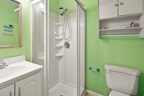 A bathroom with a shower, toilet, and a sink.