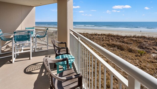 A balcony with outdoor furniture overlooking a beach. - Perfect setting for your getaway with stunning views (North Myrtle Beach)
