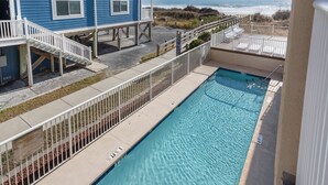 A pool with a view of the ocean, a blue building, and a white fence. - Perfect setting for your getaway with stunning views (North Myrtle Beach)