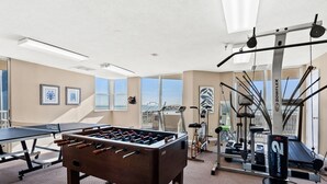 A gym with a foosball table, treadmills, and exercise equipment. - Perfect setting for your getaway with stunning views (North Myrtle Beach)