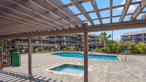 A covered outdoor swimming pool area with two pools, a pergola overhead, and a brick patio. - Upscale family resort w/all the amenities-large pool, tennis courts, hot tub and more (North Myrtle Beach)