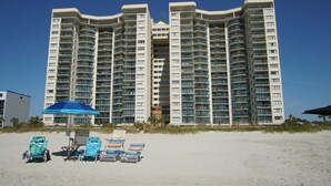 Un hotel moderno de gran altura con múltiples balcones y ubicación frente a la playa.