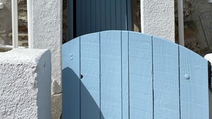 Un edificio con un cartel que dice "Bass Cottage" sobre una puerta azul.