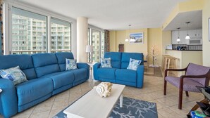 Ein Wohnzimmer mit zwei blauen Sofas, einem weißen Couchtisch und einer kleinen Dekofigur.