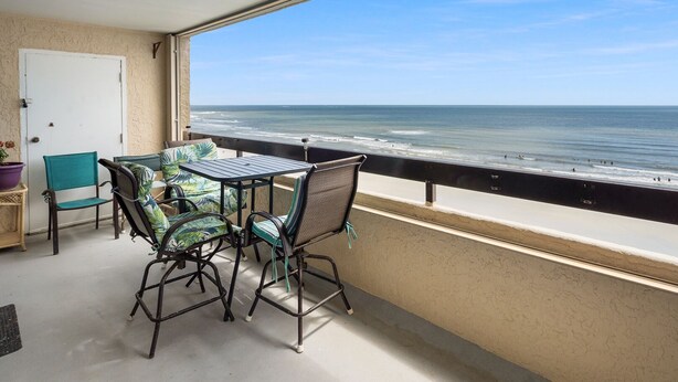 A balcony with a table and chairs overlooking the ocean. - Great oceanfront view, big balcony, & condo resort with pool & hot tub in popular Cherry Grove Beach (North Myrtle Beach)