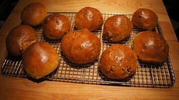 A cooling rack with several round baked goods on a wooden surface.