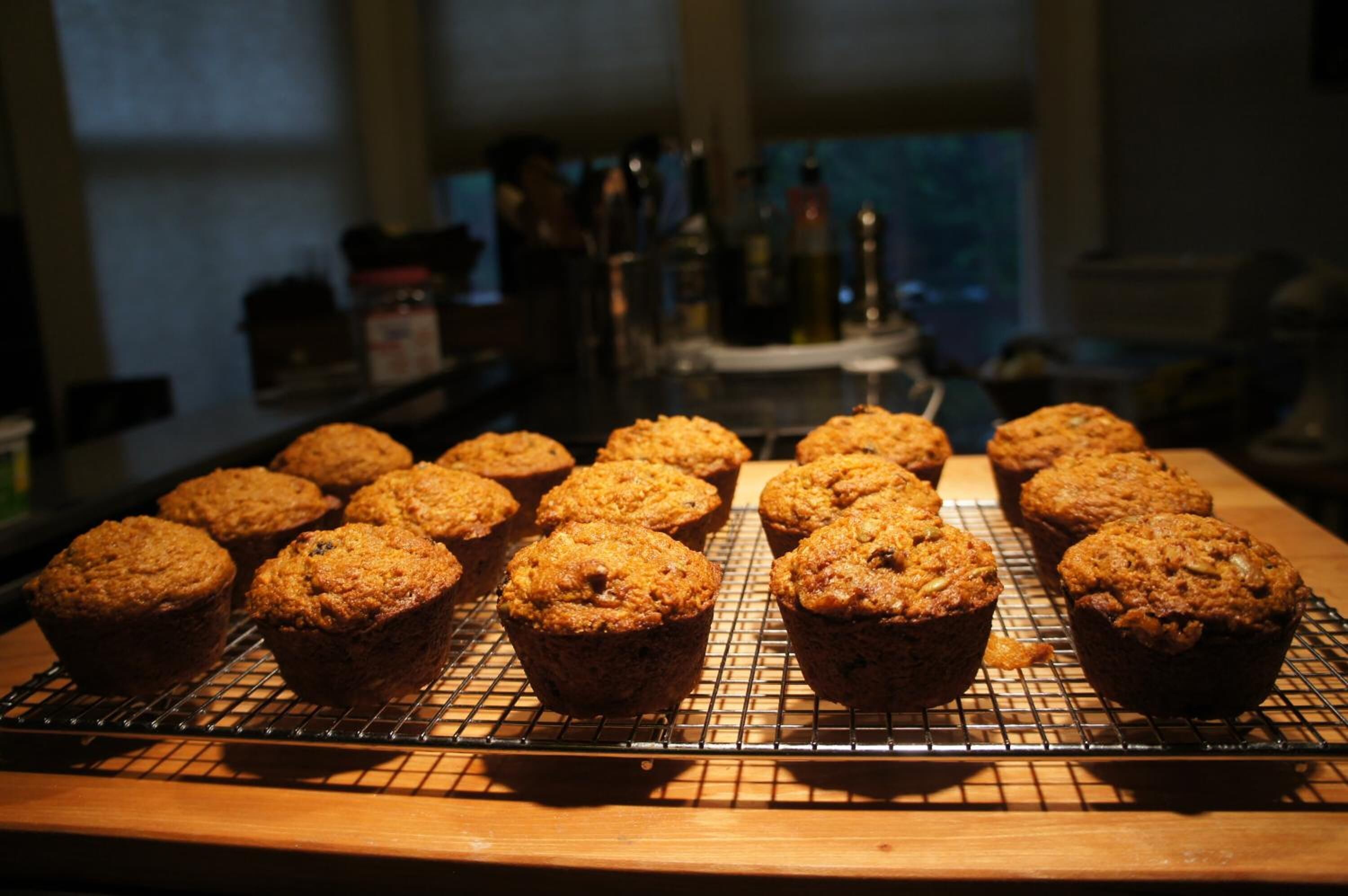 Une plaque de muffins fraîchement cuits, posée sur une grille pour qu’ils refroidissent, dans une cuisine.