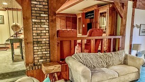 Ein gemütliches Wohnzimmer mit einer Couch, einem Sessel und einer Ziegelwand.