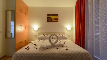 Een hotelkamer met een bed, een schilderij aan de muur en een raam met gordijnen.