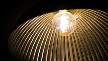 A lamp with a ribbed shade and a visible light bulb.