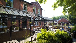 A hotel with outdoor seating and a covered patio area. - Bowling Green (Manchester)