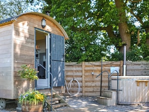 A wooden cabin with a door, a small outdoor area with steps, and a wooden fence.