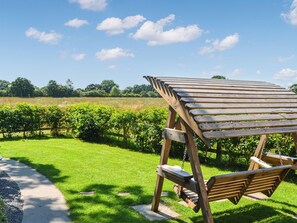 A wooden swing set in a grassy area with a clear sky and distant trees. - 1 bedroom accommodation in Strensall, near York (Strensall, near York)