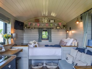 A cozy room with a bunk bed, a desk, a lamp, and a window with curtains. - 1 bedroom accommodation in Strensall, near York (Strensall, near York)