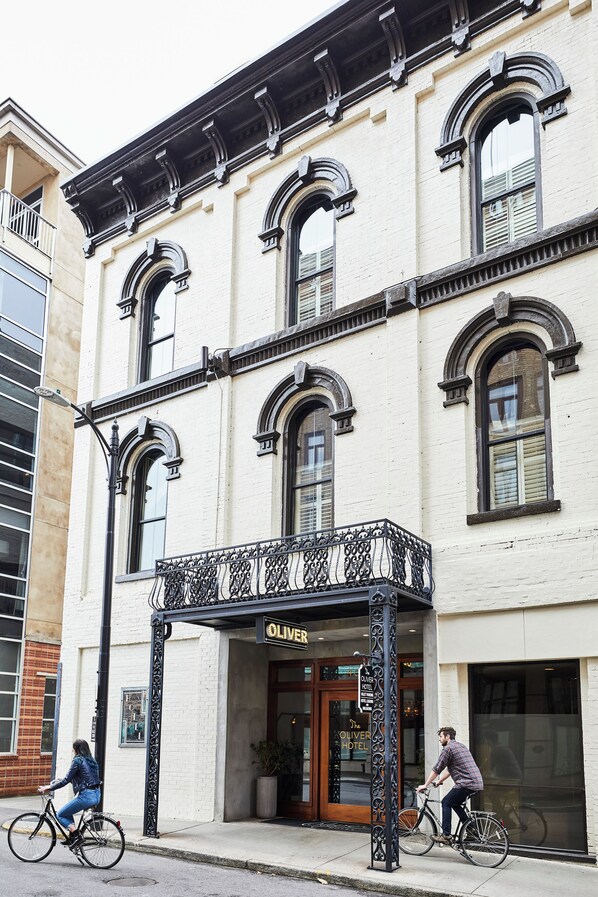 A building with a balcony and a sign that reads "OLIVER HOTEL".
