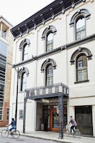 Un edificio con balcón y un cartel que dice "OLIVER HOTEL".