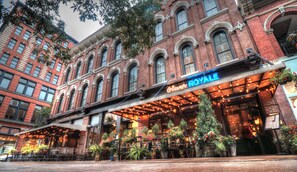 A historic building with a restaurant named "Olivier Royale" featuring outdoor seating and brick architecture. - The Oliver Hotel (Knoxville)