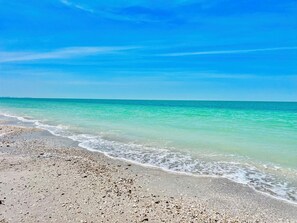 A beach with clear turquoise water and a sandy shore. - Bella Lago 241 by Distinctive Beach Rentals (Fort Myers Beach)