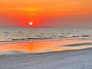 A beach with a sunset over the ocean. - Bella Lago 241 by Distinctive Beach Rentals (Fort Myers Beach)